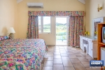 Bedroom # 1 with access to balcony overlooking resort grounds and Caribbean Sea thumbnail from Coldwell Banker