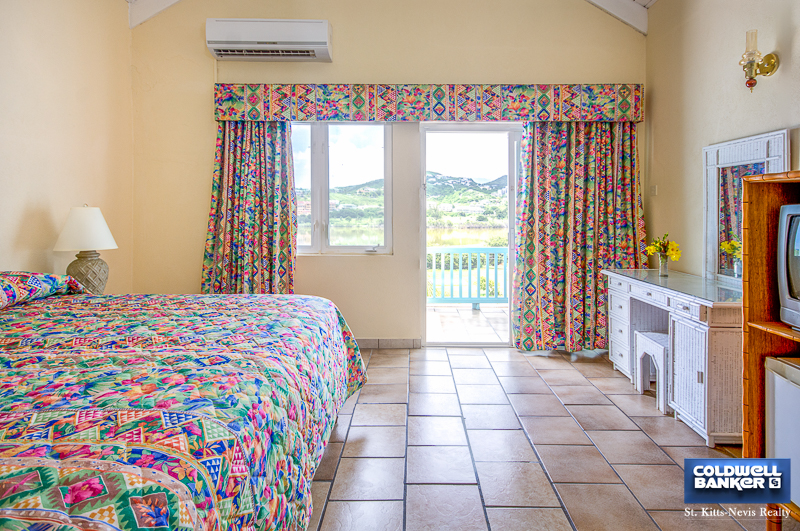 Bedroom # 1 with access to balcony overlooking resort grounds and Caribbean Sea from Oualie Realty